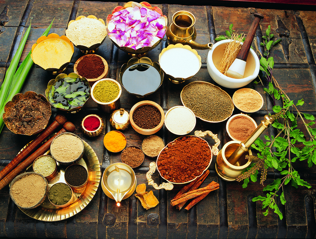 Array of spices in traditional bowls used in Ayurveda